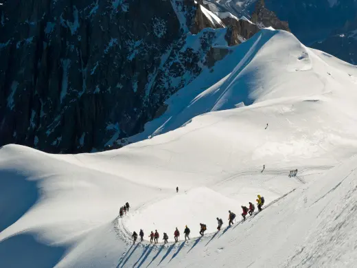 Gruppe von Wanderern erklimmt einen verschneiten Berg